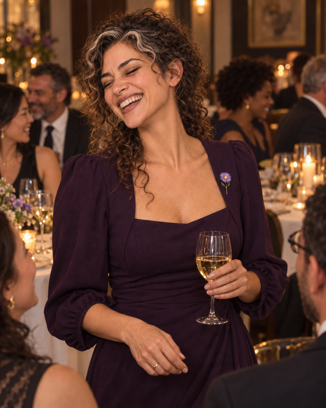 Aster Averi laughing with her eyes closed at an intimate film supper